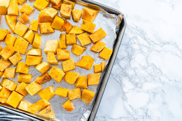 Roasting butternut squash with salt and pepper in olive oil.