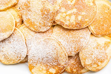 Süslü şekerle süslenmiş kefir tabanında taze yapılmış küçük krepler..