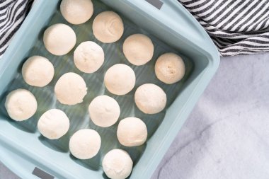 Pişirme tavasındaki önceden hazırlanmış donmuş hamur köftelerini pişiriyorum..