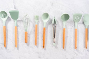 Düz yatıyordu. Ahşap saplı silikon pişirme aletleri.