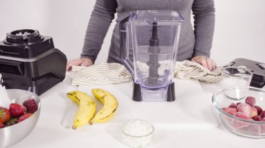 Mutfak blendırında çilekli ve muzlu smoothie hazırlıyorum..