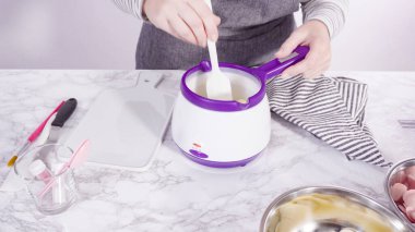 Adım adım. Çikolatalı şekerleri eritmek elektrikli bir şeker tenceresinde erir..