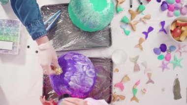 Little girl painting small craft pumpkin with acrylic paint.