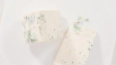 Beyaz arka planda büyük bir dilim mavi peynir..