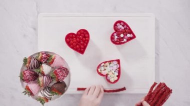  Variety of chocolate dipped strawberries in a heart shaped gift box.