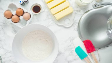 Adım adım. Düz yatıyordu. Üç katlı vanilyalı kek pişirmek için mutfak mikserinin malzemelerini karıştırıyorum..