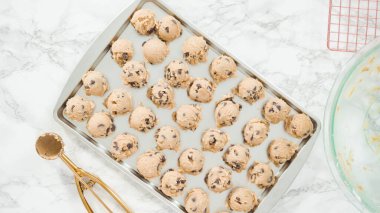 Adım adım. Düz yatıyordu. Hamur kepçesiyle ev yapımı çikolatalı kurabiyeler pişiriyorum..