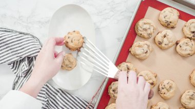 Adım adım. Düz yatıyordu. Hamur kepçesiyle ev yapımı çikolatalı kurabiyeler pişiriyorum..