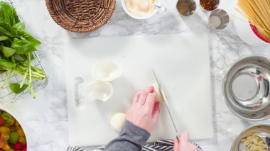 Düz yatıyordu. Adım adım. Tek demlik makarna tarifi yapmak için beyaz bir kesim tahtasıyla sebze kesmek..