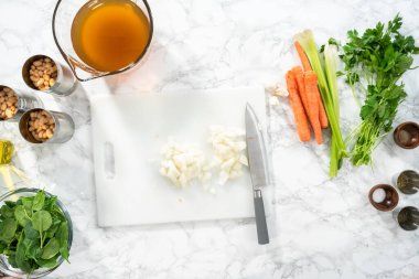 Düz yatıyordu. Beyaz kesme tahtasıyla organik sarı soğan doğramak..