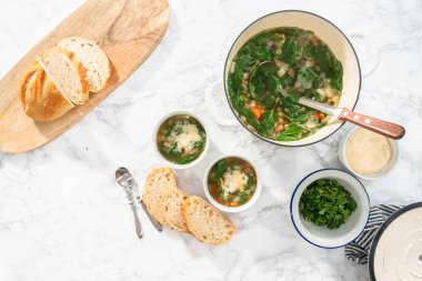 Düz yatıyordu. Beyaz kasede taze pişmiş vejetaryen beyaz fasulye çorbası..