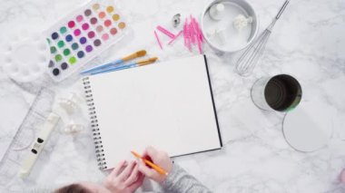 Zaman aşımı. Düz yatıyordu. Baker suluboyalı bir doğum günü pastası çiziyor..