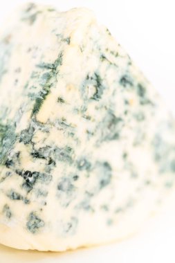 Beyaz arka planda büyük bir dilim mavi peynir..