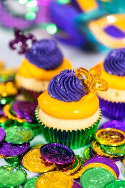 Mardi Gras vanilyalı kekler folyo kaplarda ve İtalyan tereyağlı kremayla süslenmiş..