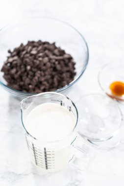 Çikolatalı keki hazırlamak için bardakta ölçülen malzemeler..