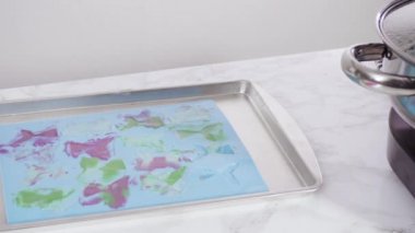 Üzerinde mavi tereyağlı krema süslemesi ve çikolata denizkızı kuyruğu ile süslenmiş gurme deniz kızı kekleri yapıyorlar..