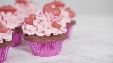 Çikolata kırmızısı kalpler ve öpücüklerle süslü kırmızı kadife kekler..