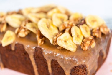 Taze pişmiş muzlu fındıklı ekmek, ev yapımı karamelli pembe kesim tahtasının üzerinde..