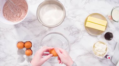 Düz yatıyordu. Adım adım. Kırmızı kadife kek pişirmek için bardakta ıslak malzemeler karıştırıyorum..