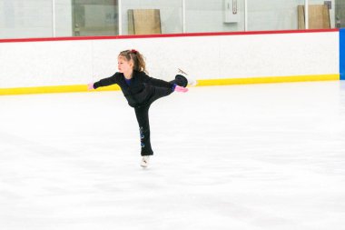 Küçük patenci sabah artistik patinaj antrenmanında elementlerini çalışıyor..