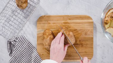Düz yatıyordu. Adım adım. Fırında pişirmek için zeytinyağı ve baharatla patates dilimliyorum..