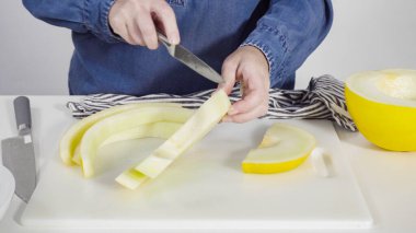 Adım adım. Beyaz kesme tahtasında kaygan altın çiğ taneli kavun.