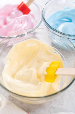 Tek boynuzlu at teması meringue popu hazırlamak için besin renklerine karıştırıyorum..