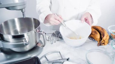 Adım adım. Muz ekmeği pişirmek için malzemeleri metal karıştırma kabına karıştırıyorum..