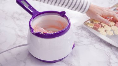 Adım adım. Çikolatalı şekerleri eritmek elektrikli bir şeker tenceresinde erir..