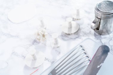 Mermer bir yüzey üzerinde kar tanesi şeklindeki kurabiye kesicilerin yakın görüntüsü.