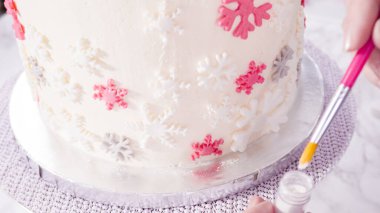 Adım adım. Yuvarlak funfetti pastasını pembe ve beyaz fondant kar taneleriyle süslüyorum..