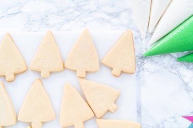 Noel şekerli kurabiyeleri süslemek kraliyet kreması ve şekerlerle.