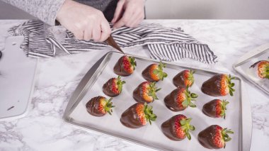 Adım adım. Çiseleyen erimiş çikolata, pasta poşetinden çikolata kaplı çileğe.