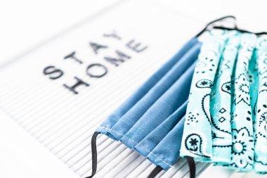 İleti panosunda ev yapımı yüz maskesi ile Ev Kal tabelası.