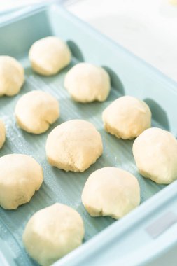 Beyaz bir tezgahın üzerinde mayalı hamurla yemek pişiriyorum..