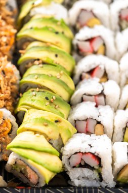 Önceden paketlenmiş suşi ve suşi çeşitleri plastik tepside..