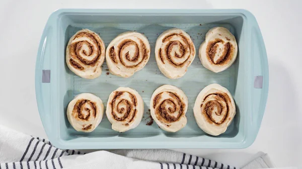 Flat lay. Unbaked cinnamon rolls in a blue baking pan.