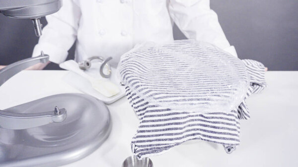 Смешивание ингредиентов в кухонном смесителе для выпечки булочек с корицей.