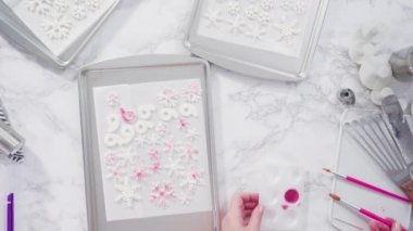 Gıda süsü ile tatlı kar taneleri yapmaktadır..