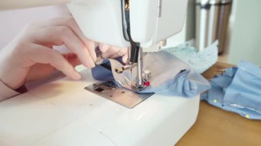 Koronavirüs salgını için dikiş makinesiyle pamuk yüz maskesi dikiyorum..