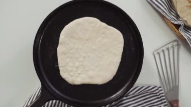 Kadın mutfakta krep pişiriyor.