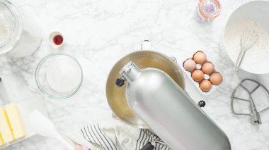 Adım adım. Düz yatıyordu. Şekerli kurabiye pişirmek için mutfak mikserinin malzemelerini karıştırıyorum..