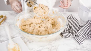 Adım adım. Çikolata parçacıklı kurabiye yapmak için cam kasede malzemeleri karıştırıyorum..