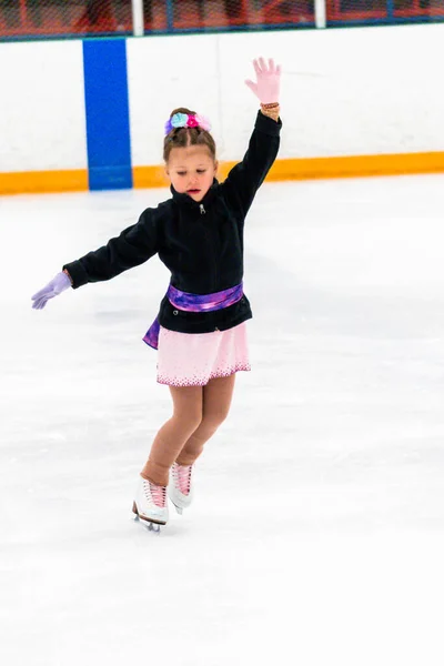 Kleines Mädchen Übt Eiskunstlauf Elemente Einem Rosa Kleid Mit Strass — Stockfoto