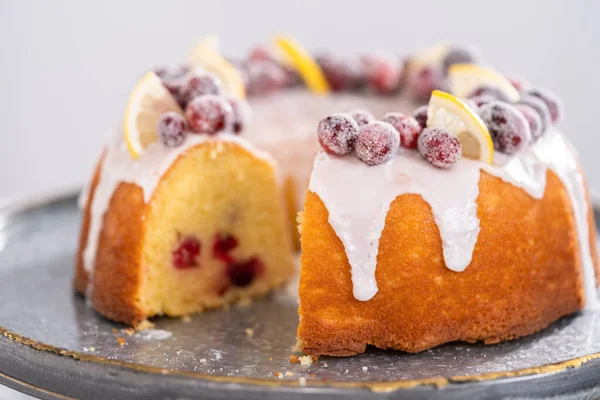 Dilimlenmiş limonlu kek. Şeker kızılcıkları ve limon dilimleri ile süslenmiş..