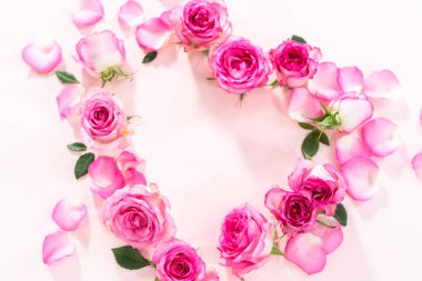 Düz yatıyordu. Pembe güllerden yapılmış kalp şekli ve pembe arka planda gül yaprakları..