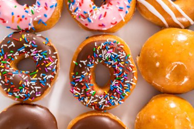 Beyaz bir karton kutuda mağazadan alınmış donutların çeşitliliği.