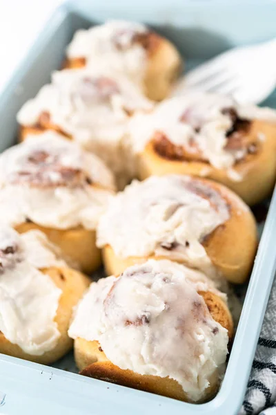 Vers Gebakken Kaneelbroodjes Met Witte Glazuur Een Blauwe Bakvorm — Stockfoto