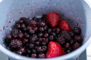 Donmuş böğürtlenlerin karışımını yapışmaz bir tencerede hazırlıyorum..