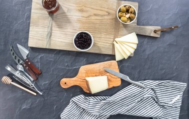 Düz yatıyordu. Aperatif peynir tahtası oluşturmak için tahta kesme tahtasına peynir, kraker ve meyve yerleştirmek..